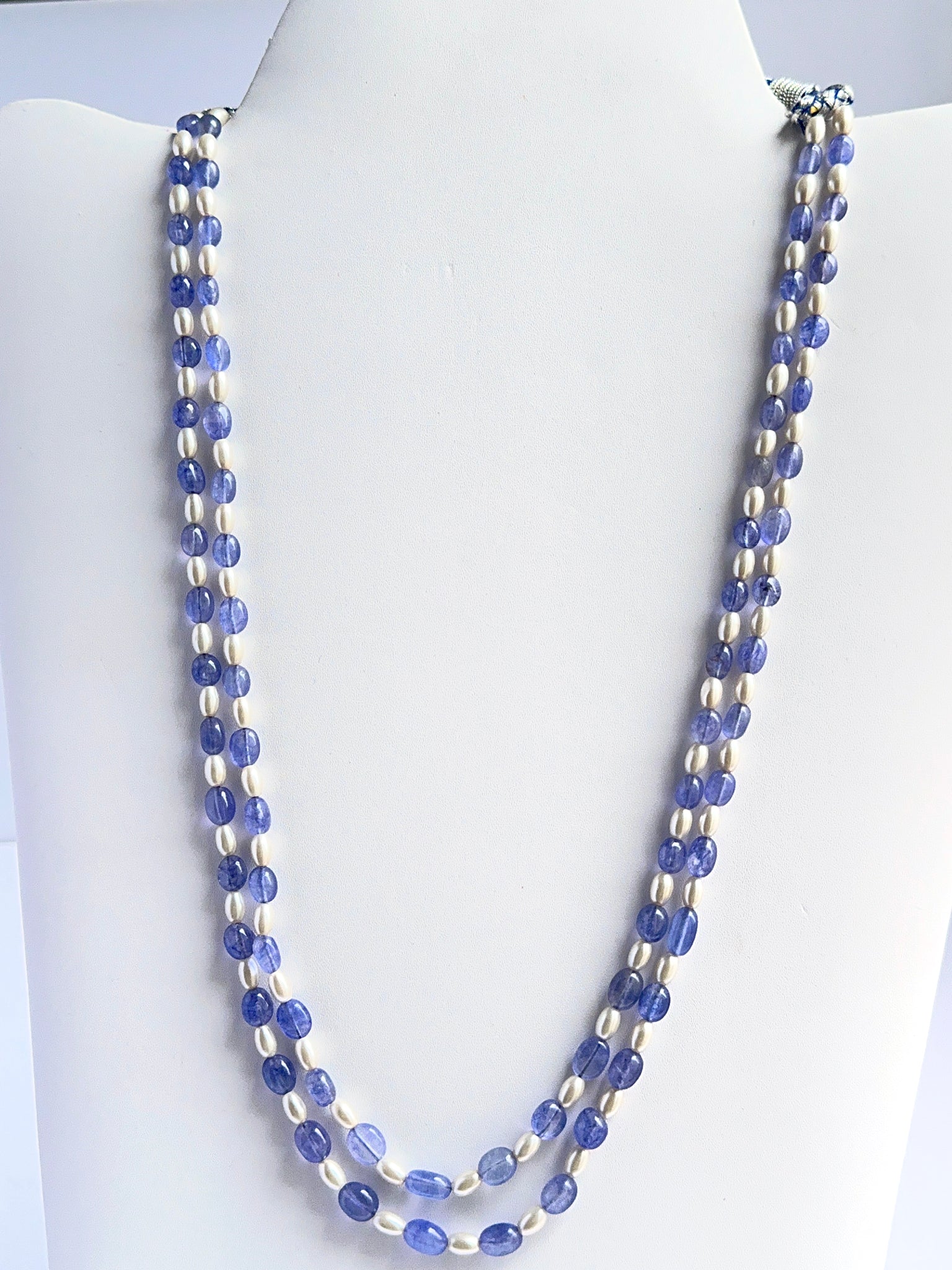 Close‑up of quartz and shell pearl beads arranged on a polished two‑strand necklace.