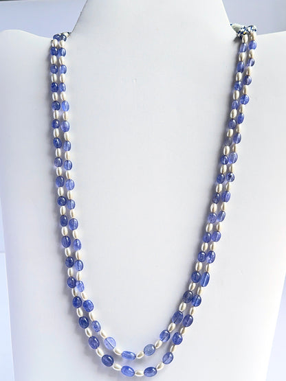 Close‑up of quartz and shell pearl beads arranged on a polished two‑strand necklace.
