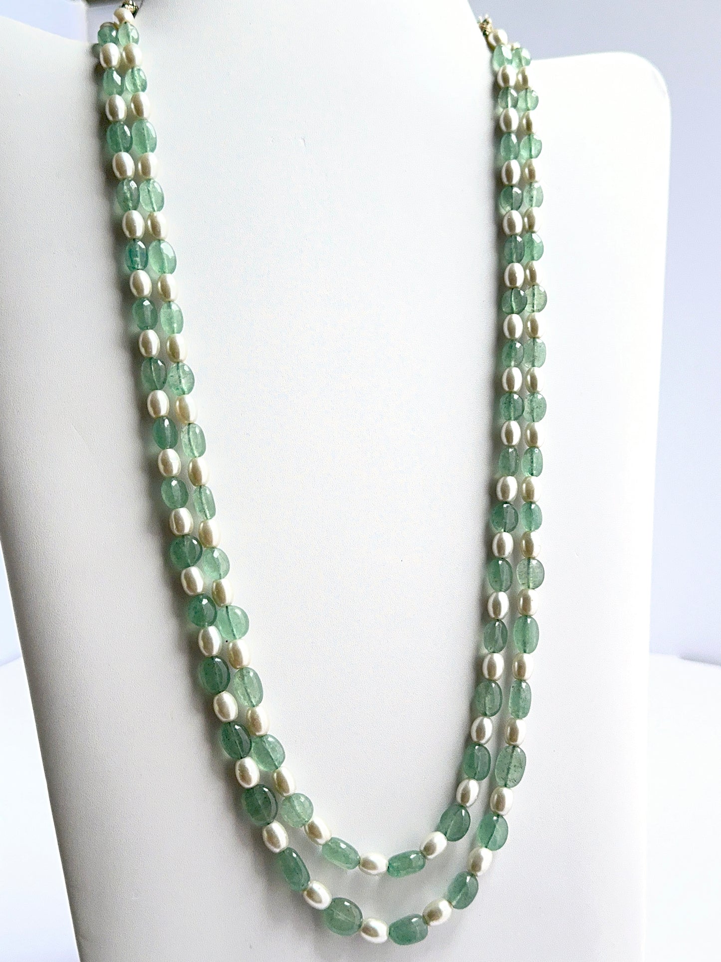 Close‑up of quartz and shell pearl beads arranged on a finished necklace.