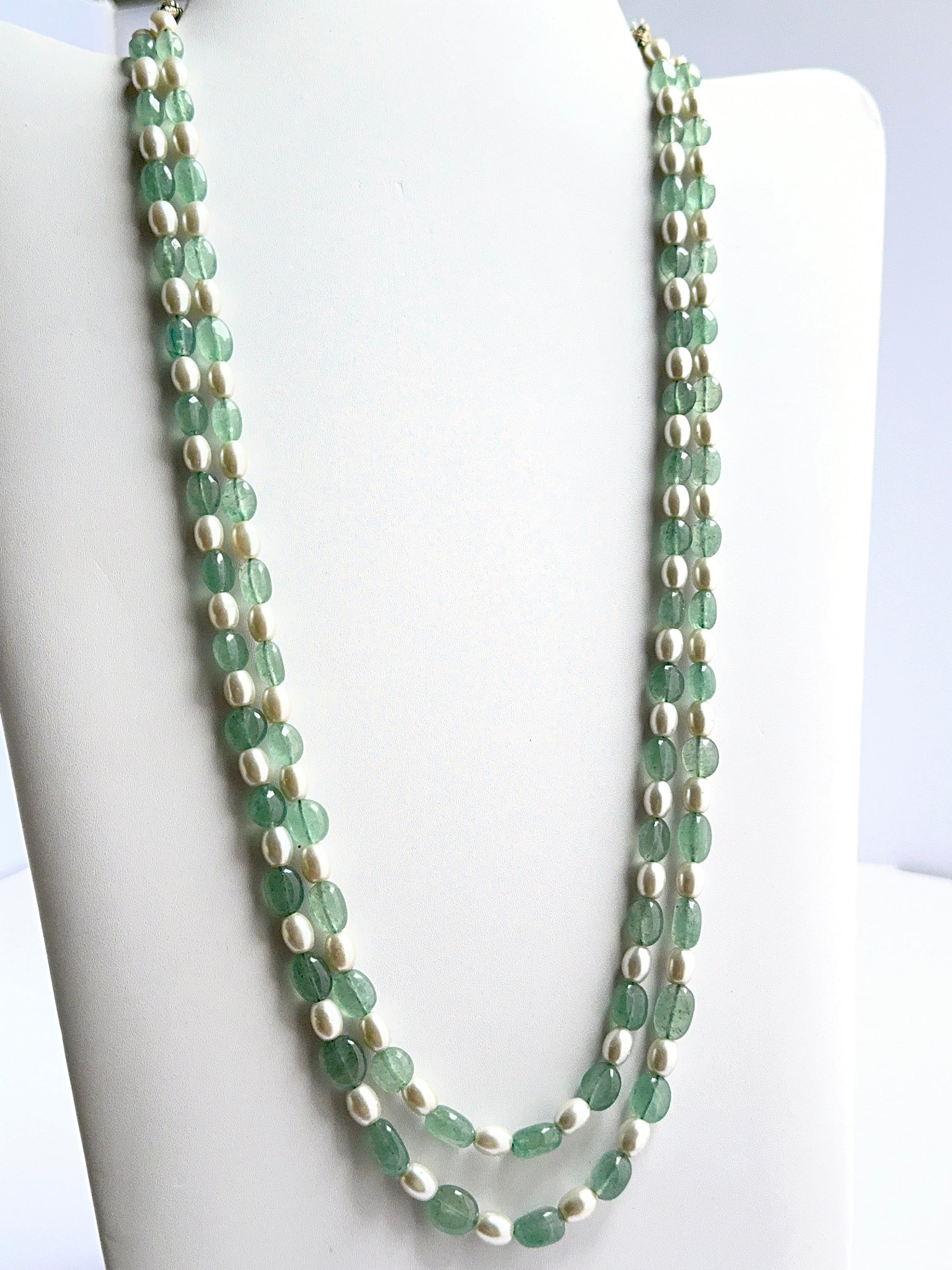 Close‑up of quartz and shell pearl beads arranged on a finished necklace.