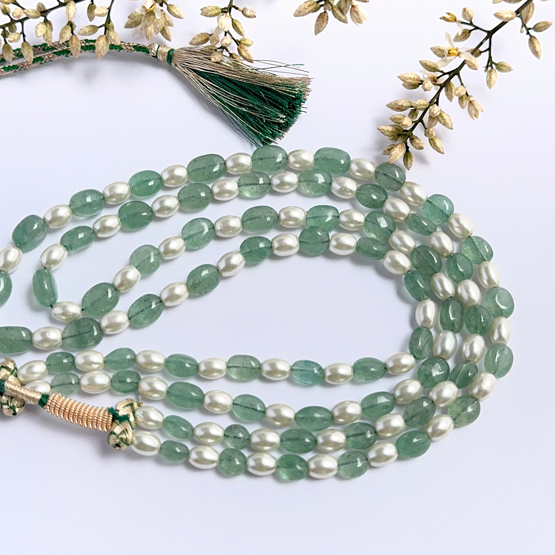 Elegant gemstone necklace featuring quartz and shell pearls in a layered layout.