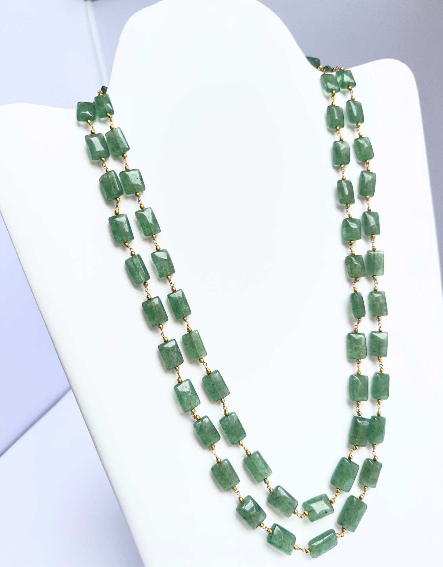 Close-up of quartz gemstone beads, rectangular cut, smooth clarity, arranged in dual strands.