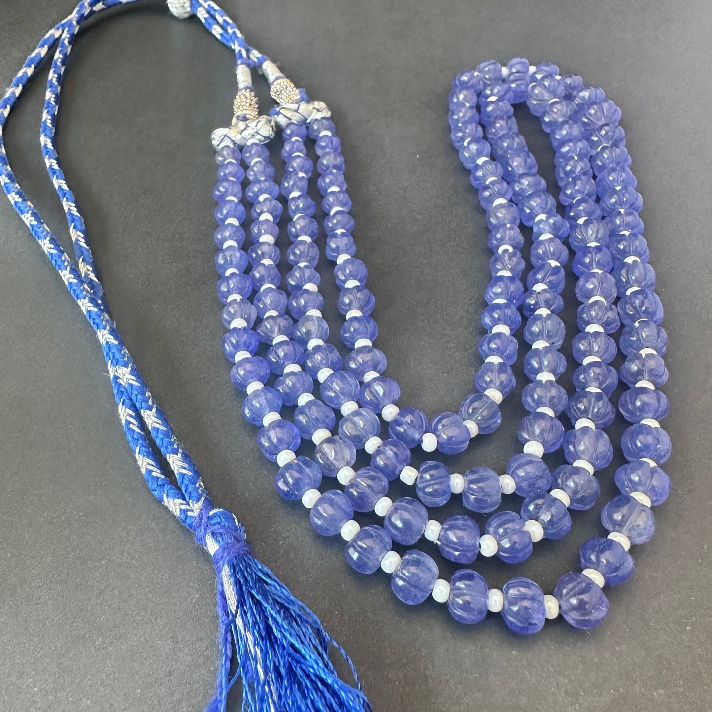 Close-up of melon-cut quartz beads, 304 carats, highlighting clarity and natural gemstone beauty.