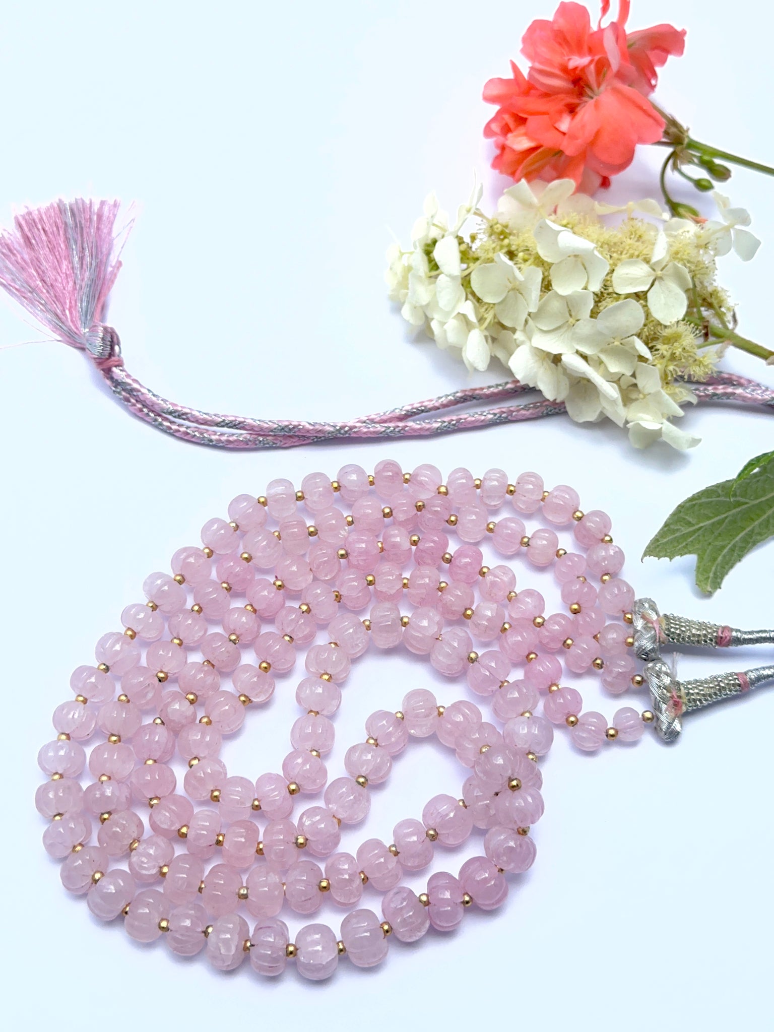 Elegant rose quartz necklace featuring pumpkin‑shaped beads in a layered design.