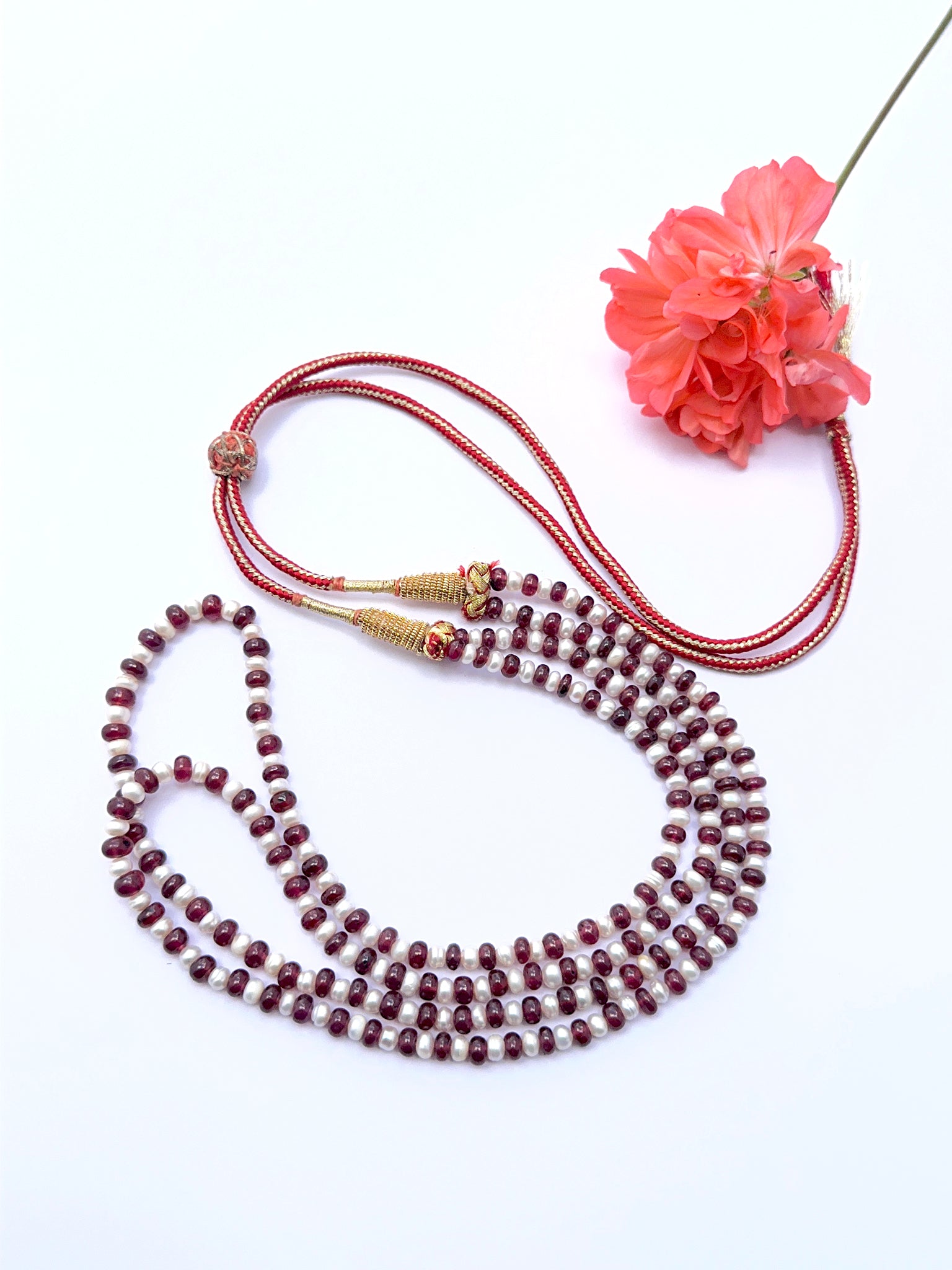 Ruby and pearl necklace with smooth rondelle beads showing bright red tones.