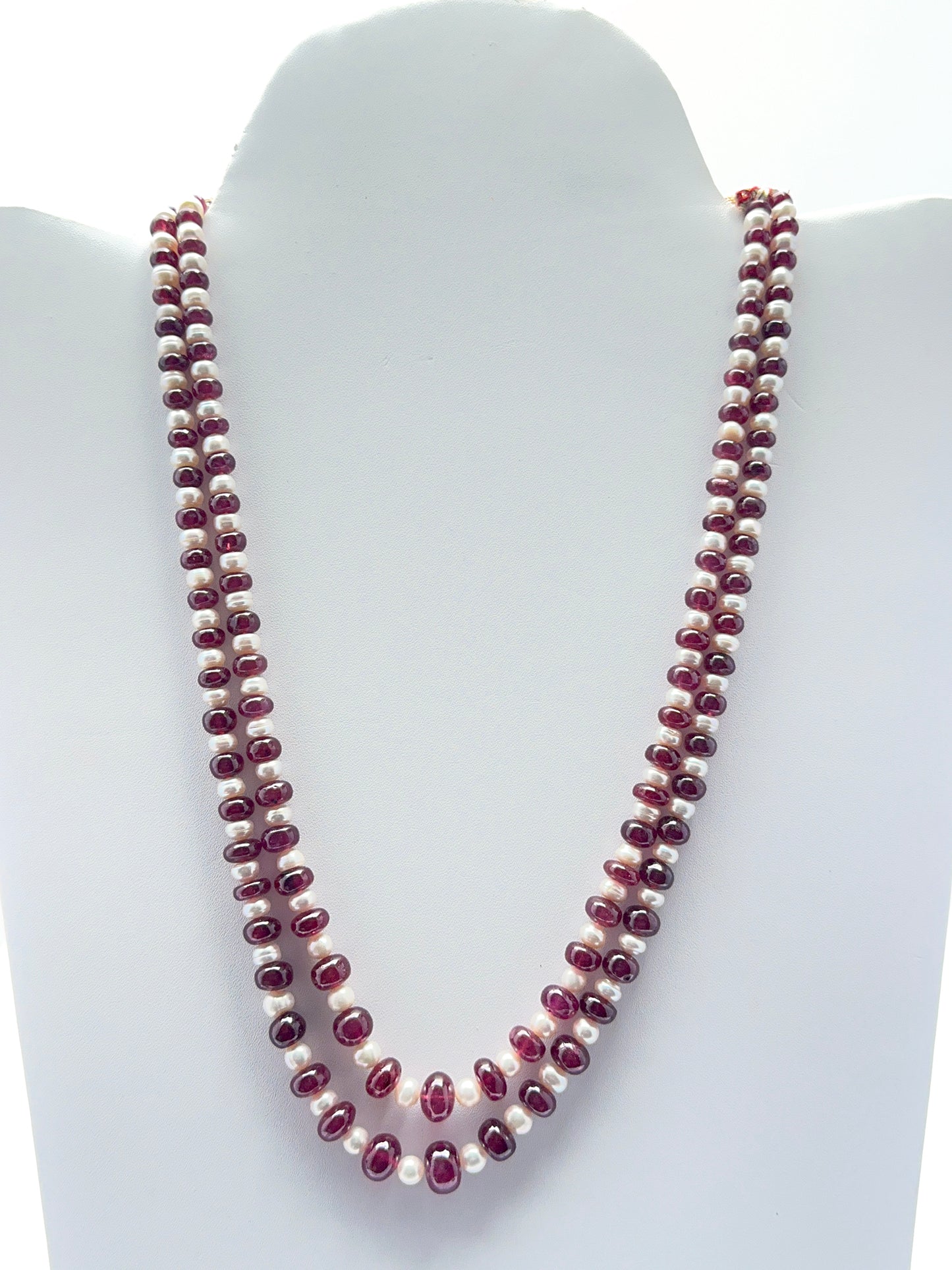 Two‑strand ruby and freshwater pearl necklace featuring smooth rondelle ruby beads in rich red tones.
