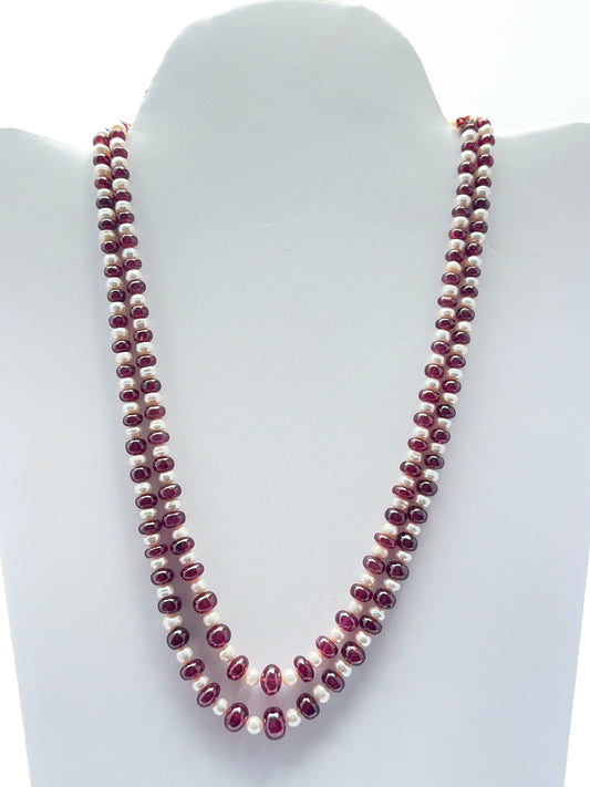 Two‑strand ruby and freshwater pearl necklace featuring smooth rondelle ruby beads in rich red tones.