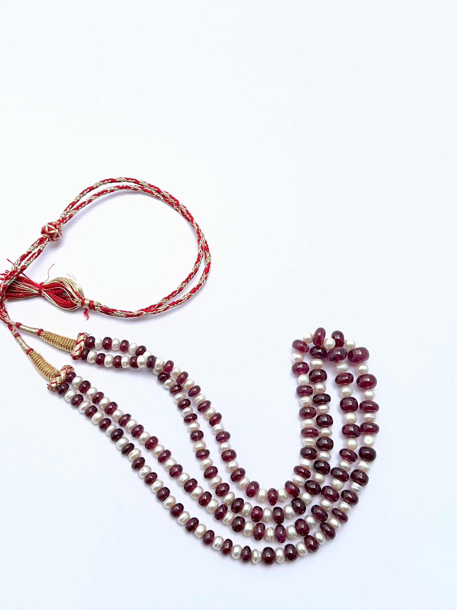 Elegant ruby and pearl necklace featuring polished rondelle beads in a balanced layout.