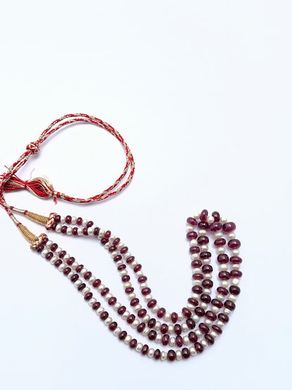 Elegant ruby and pearl necklace featuring polished rondelle beads in a balanced layout.