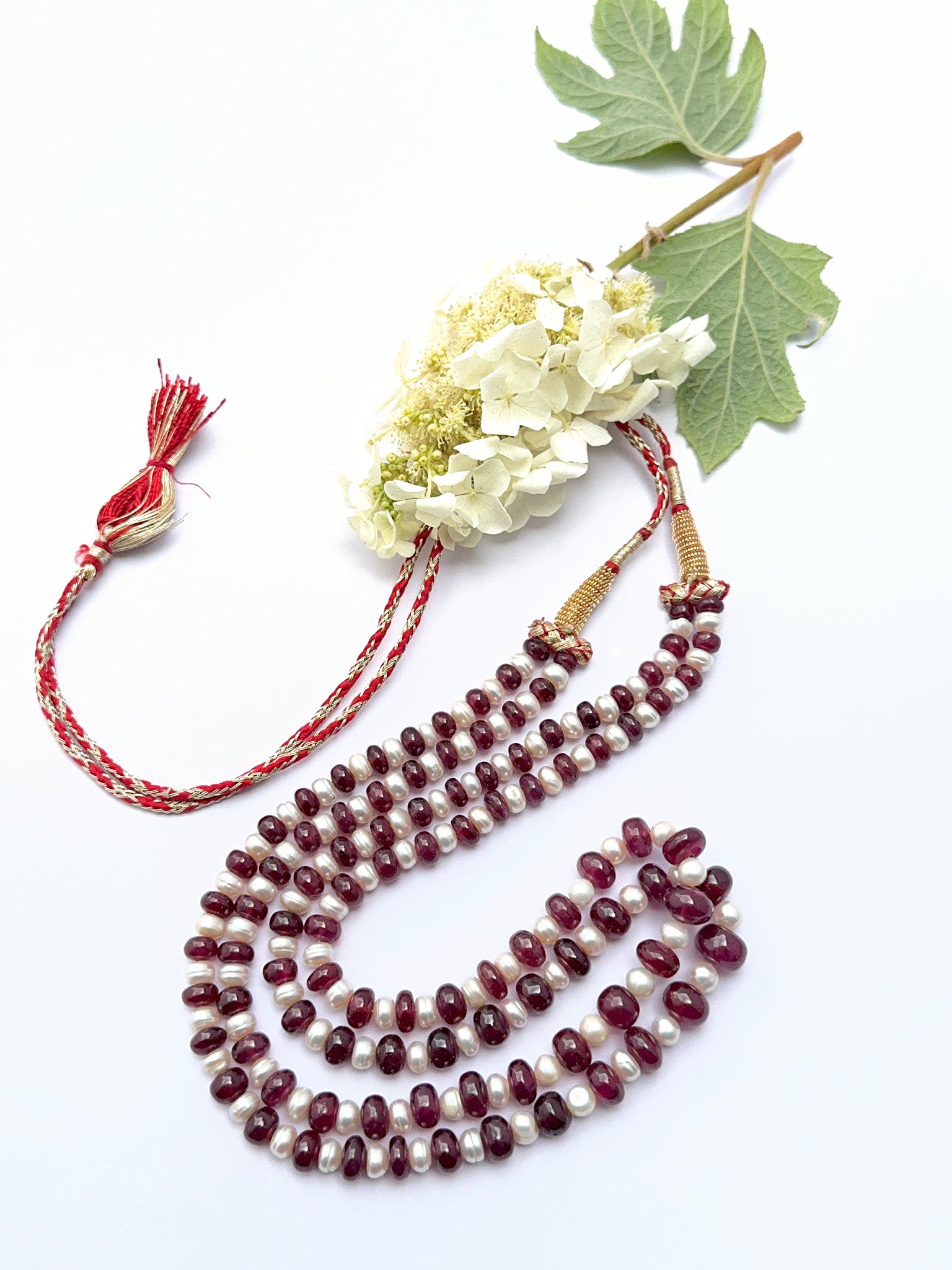 Ruby and pearl necklace with smooth rondelle beads showing vibrant colour and soft lustre.