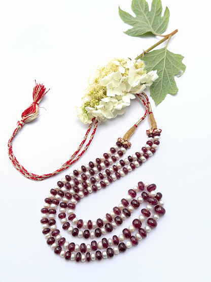 Ruby and pearl necklace with smooth rondelle beads showing vibrant colour and soft lustre.