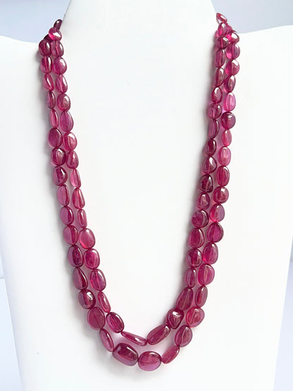 Two‑strand ruby necklace featuring smooth tumble beads in deep red tones.