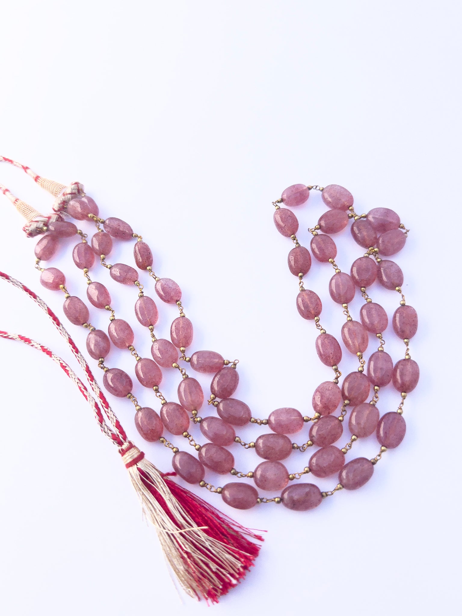 Strawberry Quartz gemstone beads necklace, polished oval cut, radiant shine, silk tassel detail.
