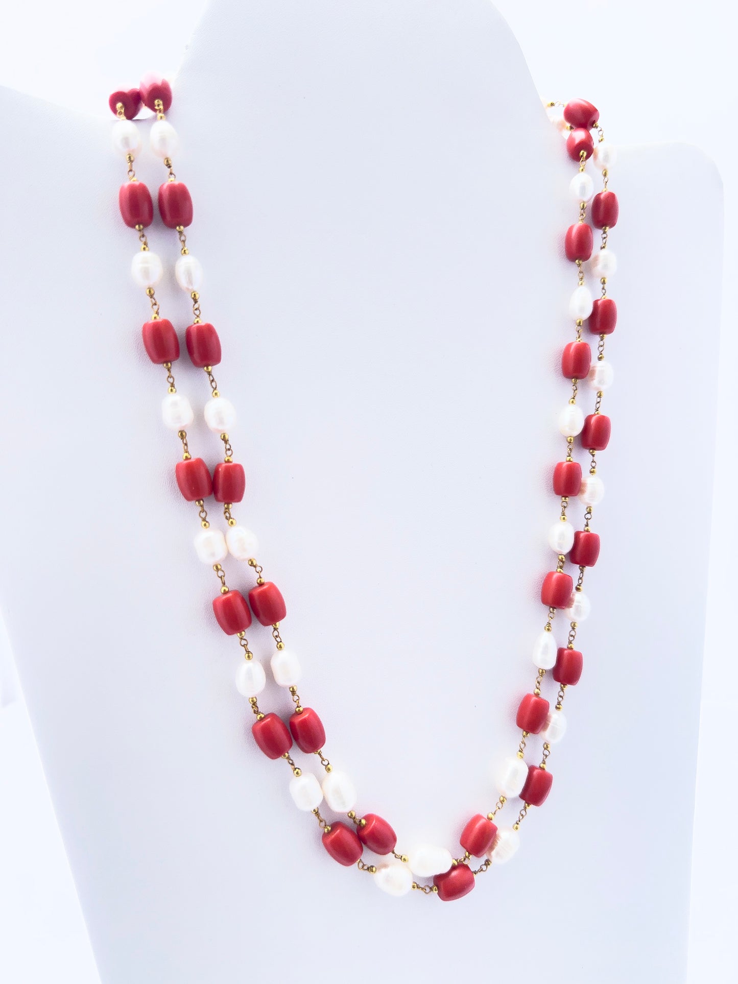Necklace showcasing natural coral and pearls, smooth drum cut, versatile styling.