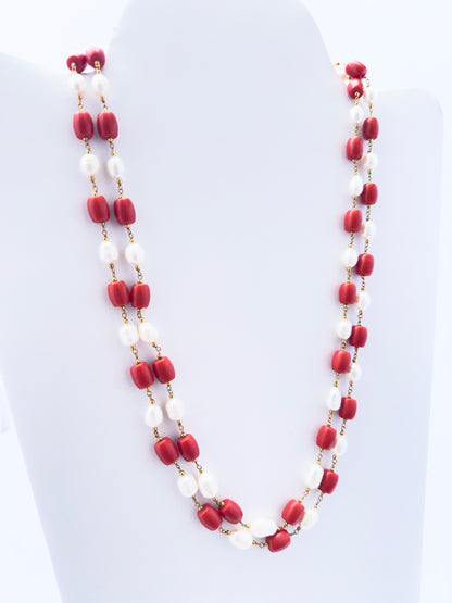 Necklace showcasing natural coral and pearls, smooth drum cut, versatile styling.