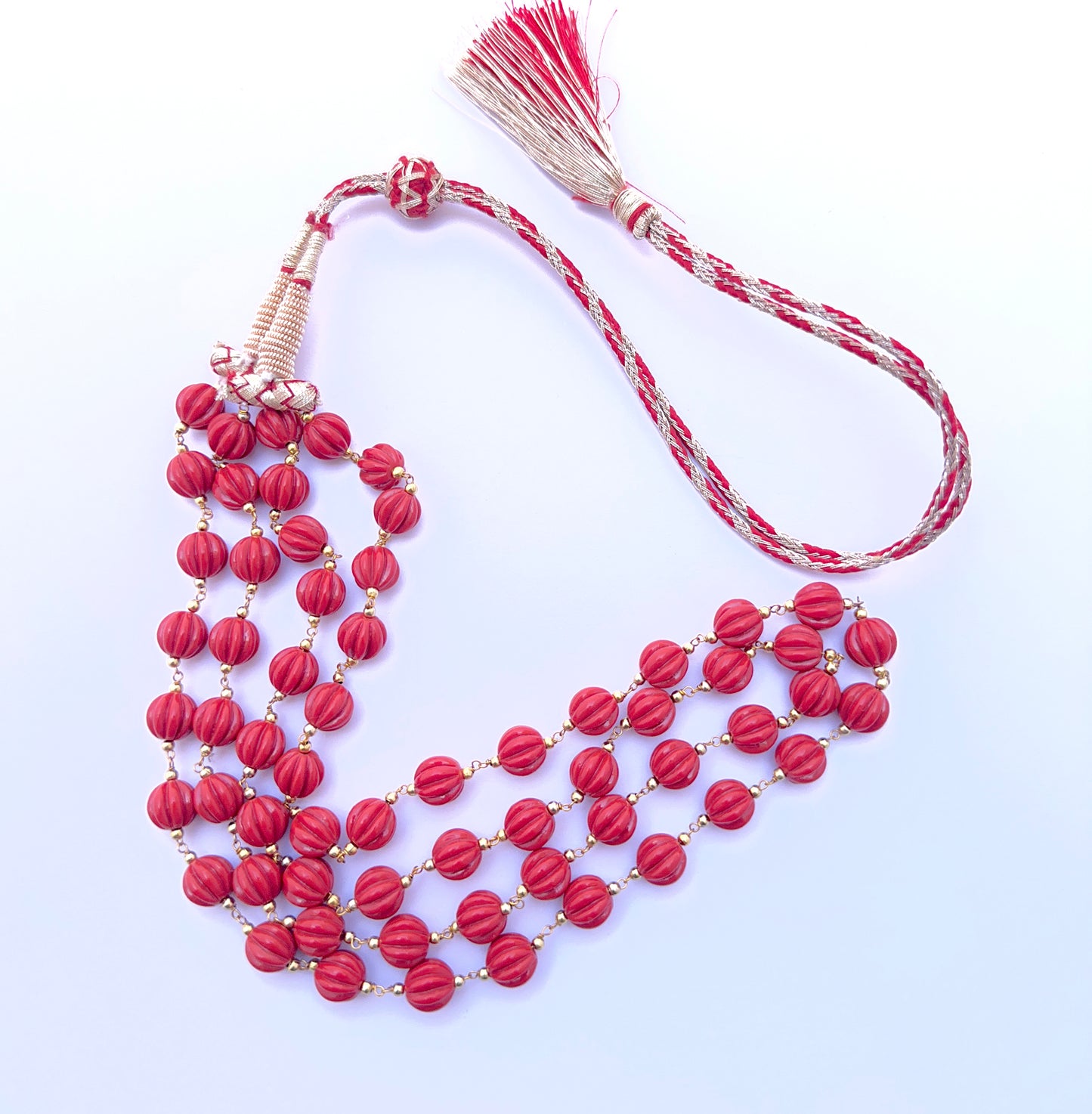 Natural coral necklace with carved beads arranged in a refined two‑strand layout.