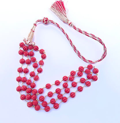 Natural coral necklace with carved beads arranged in a refined two‑strand layout.