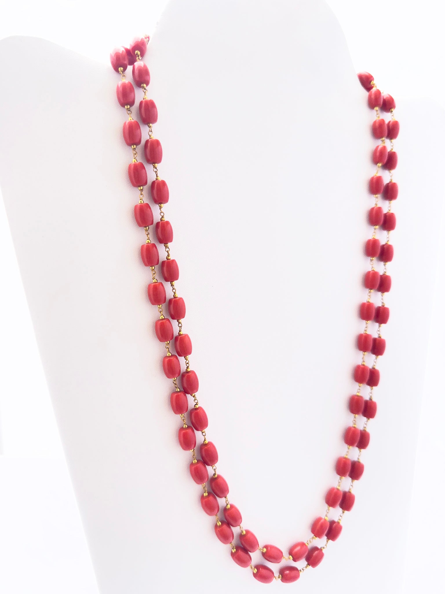 Close-up of Taiwan Coral gemstone beads, smooth drum cut, polished finish, arranged in strands.