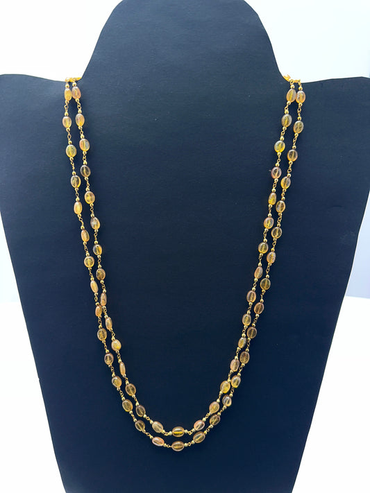 Two‑strand yellow sapphire necklace featuring smooth oval beads in bright golden tones.