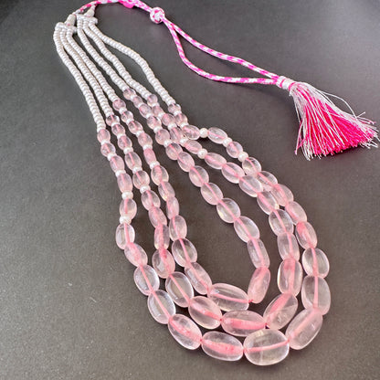 Rose quartz and shell pearls arranged in elegant strands for refined jewellery styling.