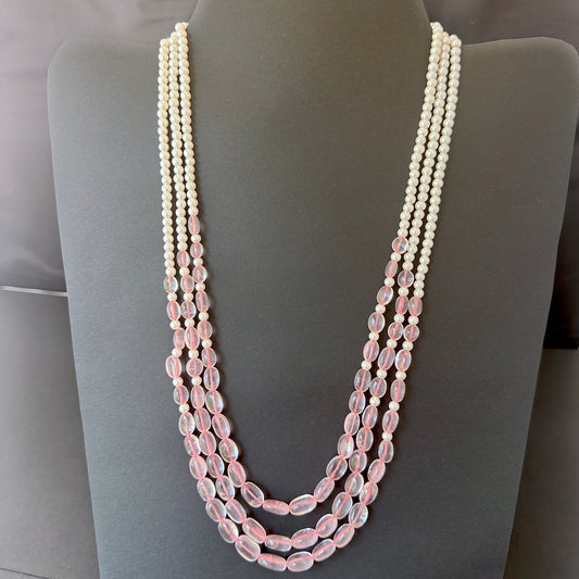 Three-strand necklace with rose quartz ovals and shell pearls in soft pink and white hues.