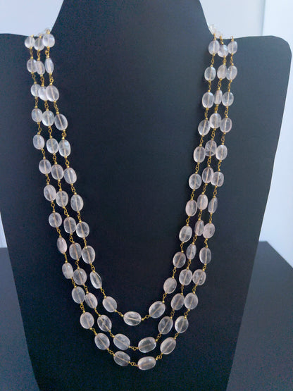 Close-up of Strawberry Quartz gemstone beads, faceted oval cut, shimmering brilliance, arranged in strands.