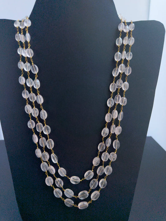 Close-up of Strawberry Quartz gemstone beads, faceted oval cut, shimmering brilliance, arranged in strands.