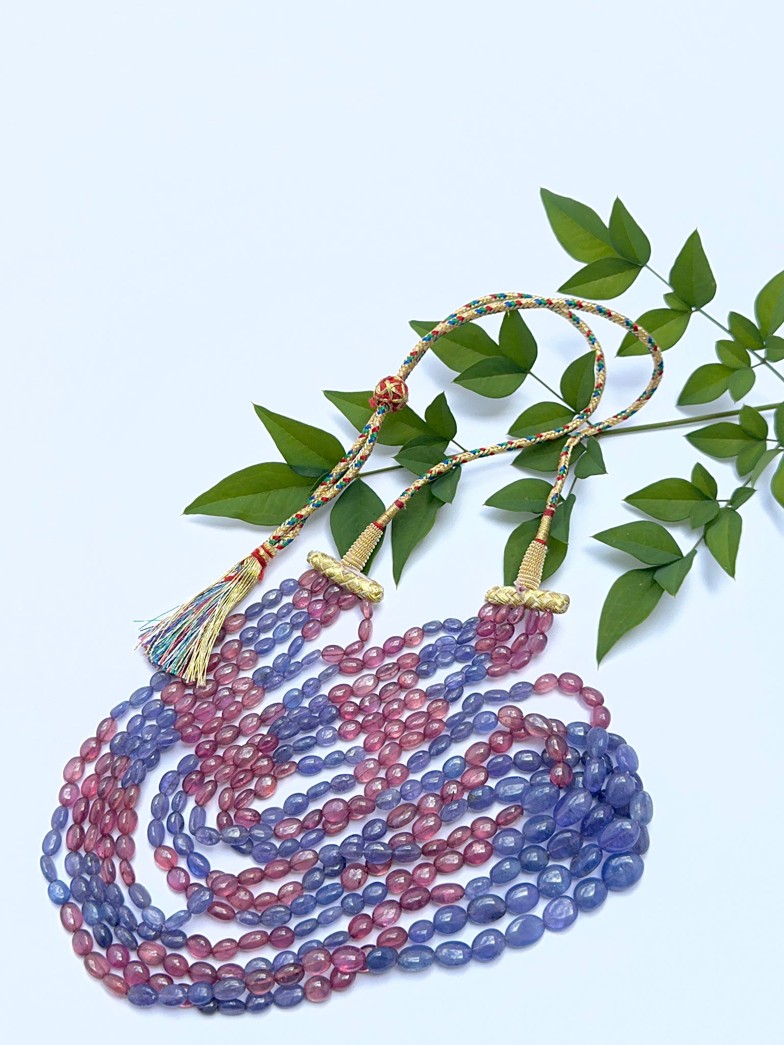 Ruby and tanzanite necklace with smooth oval beads showing rich red and violet hues.