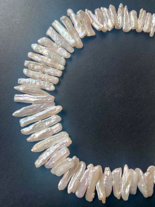 Close-up of Baroque pearl beads showing their 18–24mm length and 4.5–5.5mm breadth.