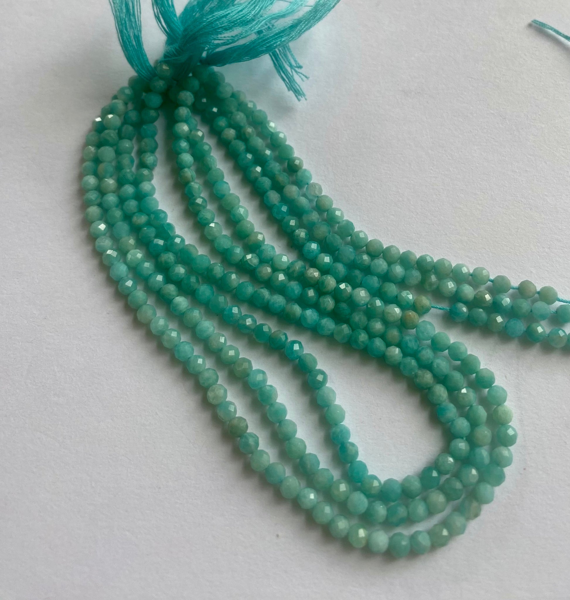 A close-up of a multiple strands  featuring Amazonite faceted rondelle beads, measuring 3.4-3.5mm in size.