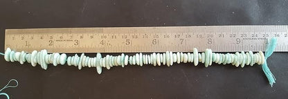 Close-up of a ruler alongside green amazonite beads, showcasing their shape and size.