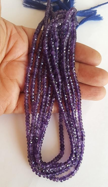  A person holding a faceted rondelle amethyst gemstone strand, showcasing its purple facets and elegant design.