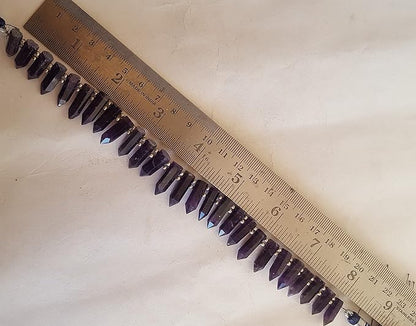 A purple gemstone bead strand showcasing Amethyst smooth pencil shaped gemstones.