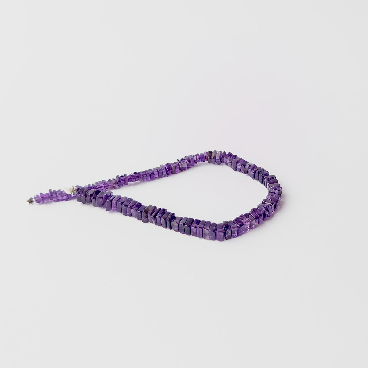High quality Amethyst stone beads arranged on a strand with polished surfaces and versatile design potential.