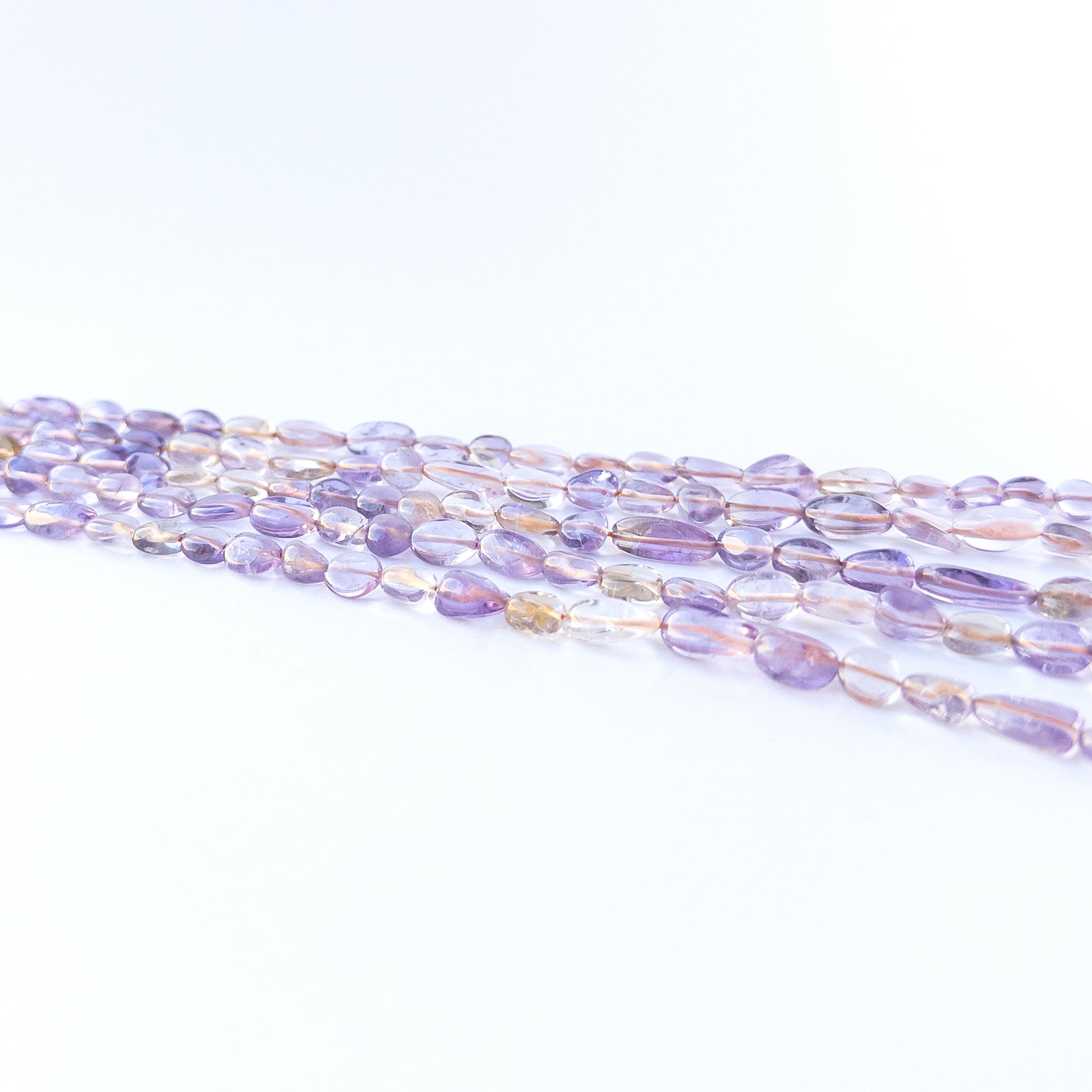 Ametine smooth tumble gemstone beads in blended purple‑gold tones arranged on a 32cm strand for handmade jewellery components.