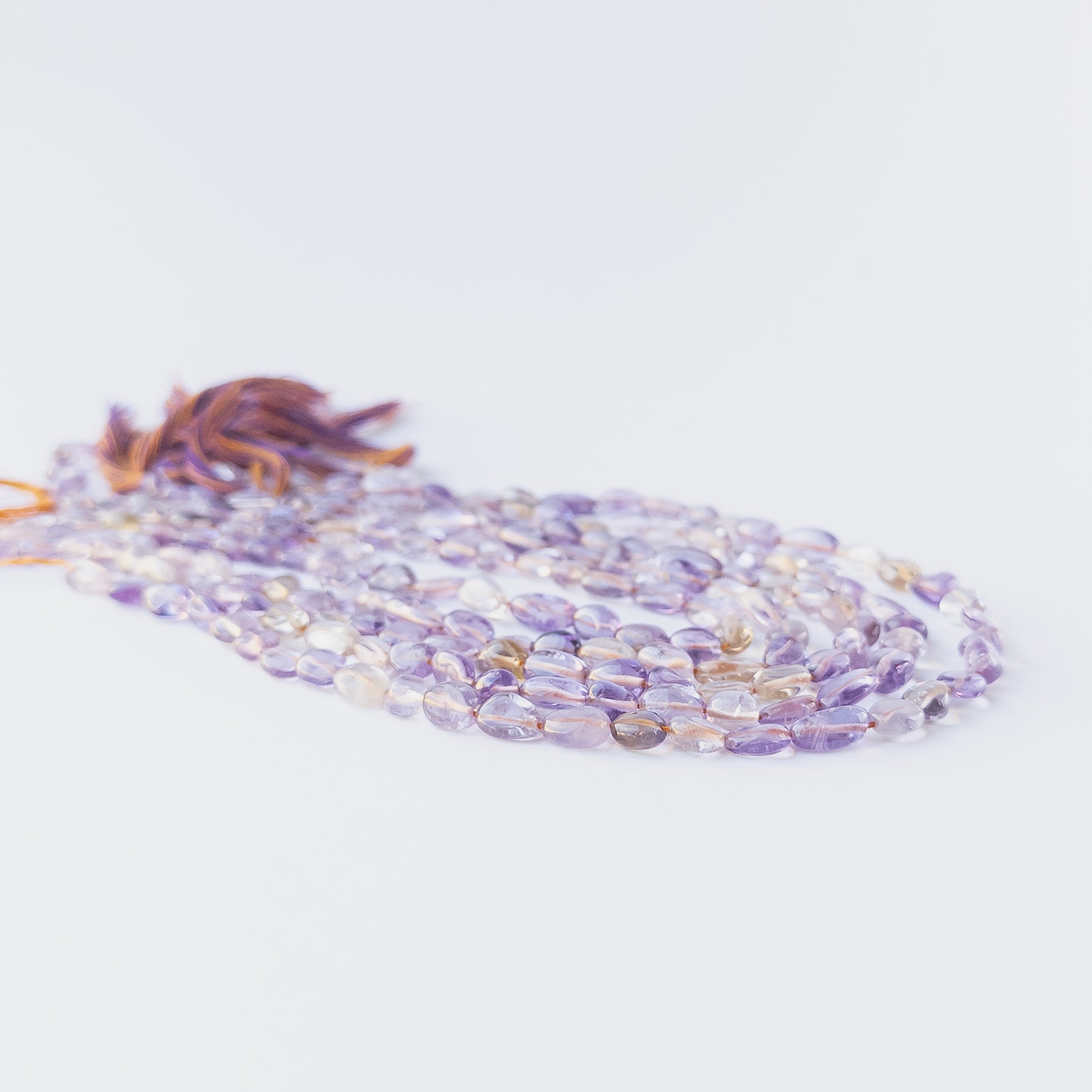 High‑quality Ametine smooth tumble beads in 6–6.5mm size offering clarity and shine for artisan jewellery projects.