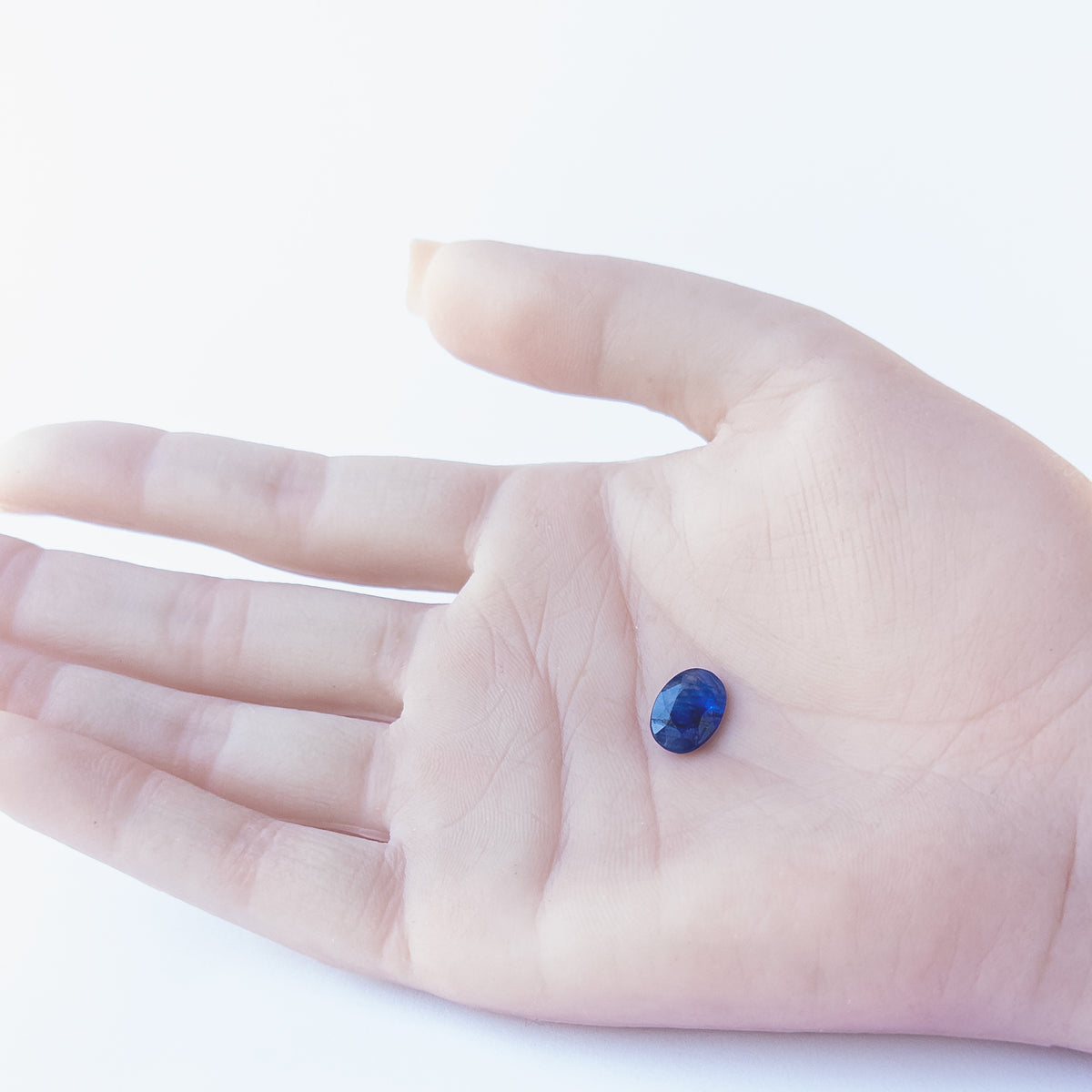 Genuine Blue Sapphire stone cabochon showcasing its faceted oval cut and rich midnight‑blue tone.