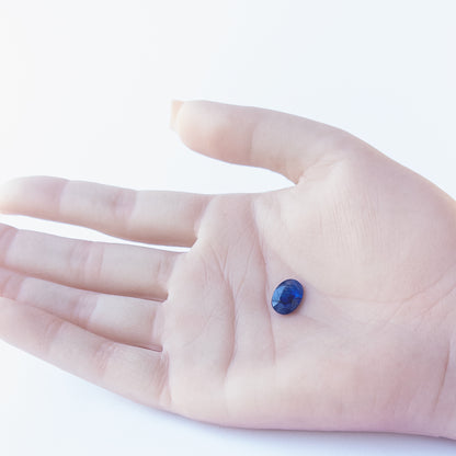 Genuine Blue Sapphire stone cabochon showcasing its faceted oval cut and rich midnight‑blue tone.
