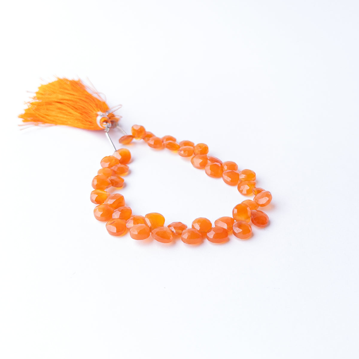 Carnelian faceted briolette gemstone beads displaying rich orange red hues with brilliant sparkle and elegant precision cutting.