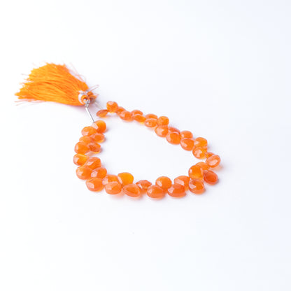 Carnelian faceted briolette gemstone beads displaying rich orange red hues with brilliant sparkle and elegant precision cutting.