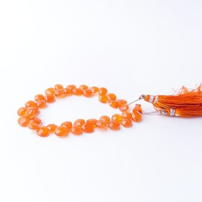 Genuine Carnelian gemstone beads arranged on a strand with vibrant colour and exceptional light reflection.