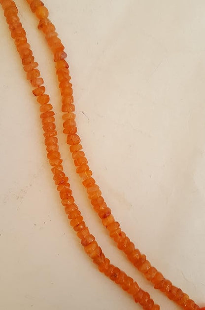 Strand  featuring smooth carnelian smooth wheel beads, each measuring 6mm, showcasing a vibrant orange colour.