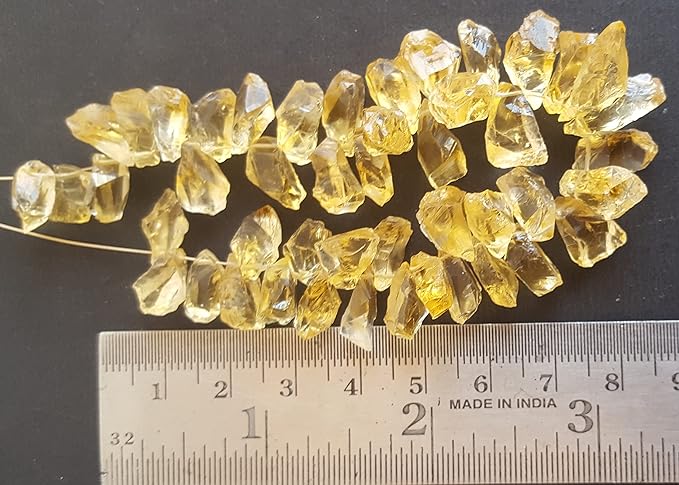 A ruler beside a cluster of yellow citrine gemstone beads, measuring 7mm to 8mm in size.