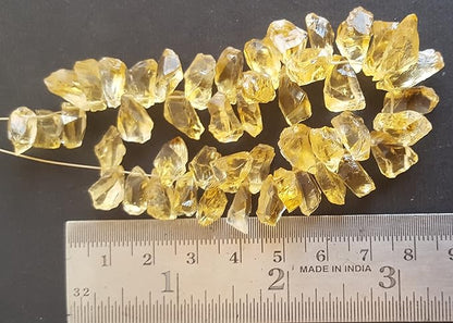 A ruler beside a cluster of yellow citrine gemstone beads, measuring 7mm to 8mm in size.