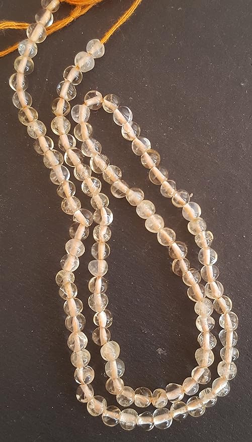 An array of smooth Citrine beads, 3.5mm in size, gathered together, emphasising their stunning colour.