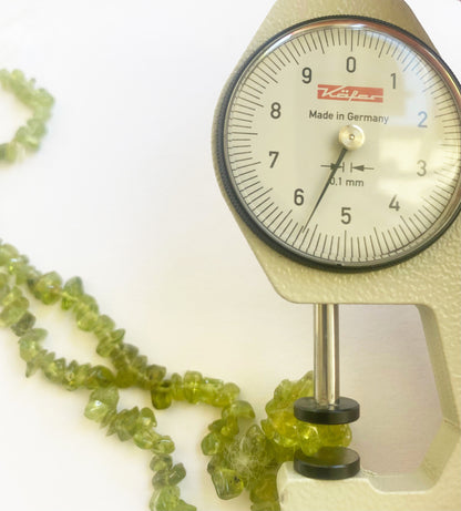 Premium Peridot chip beads 5 to 8mm arranged in strands to display their vibrant green tones and superior gemstone craftsmanship.
