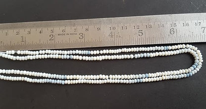  A denim opal stand made of faceted, rondelle beads, with a ruler beside it for size reference. 