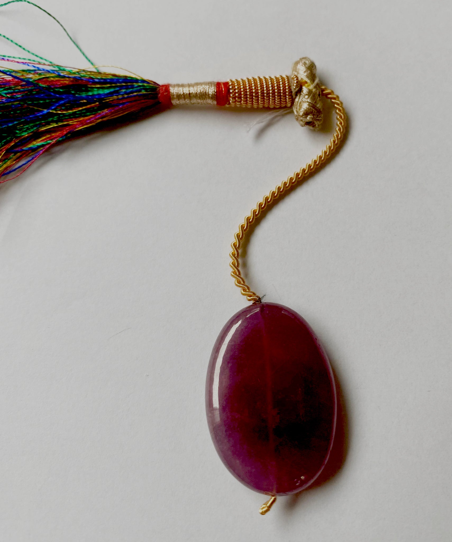 Ruby pendant positioned to showcase depth, clarity, and consistent cut with drilled hole detail.