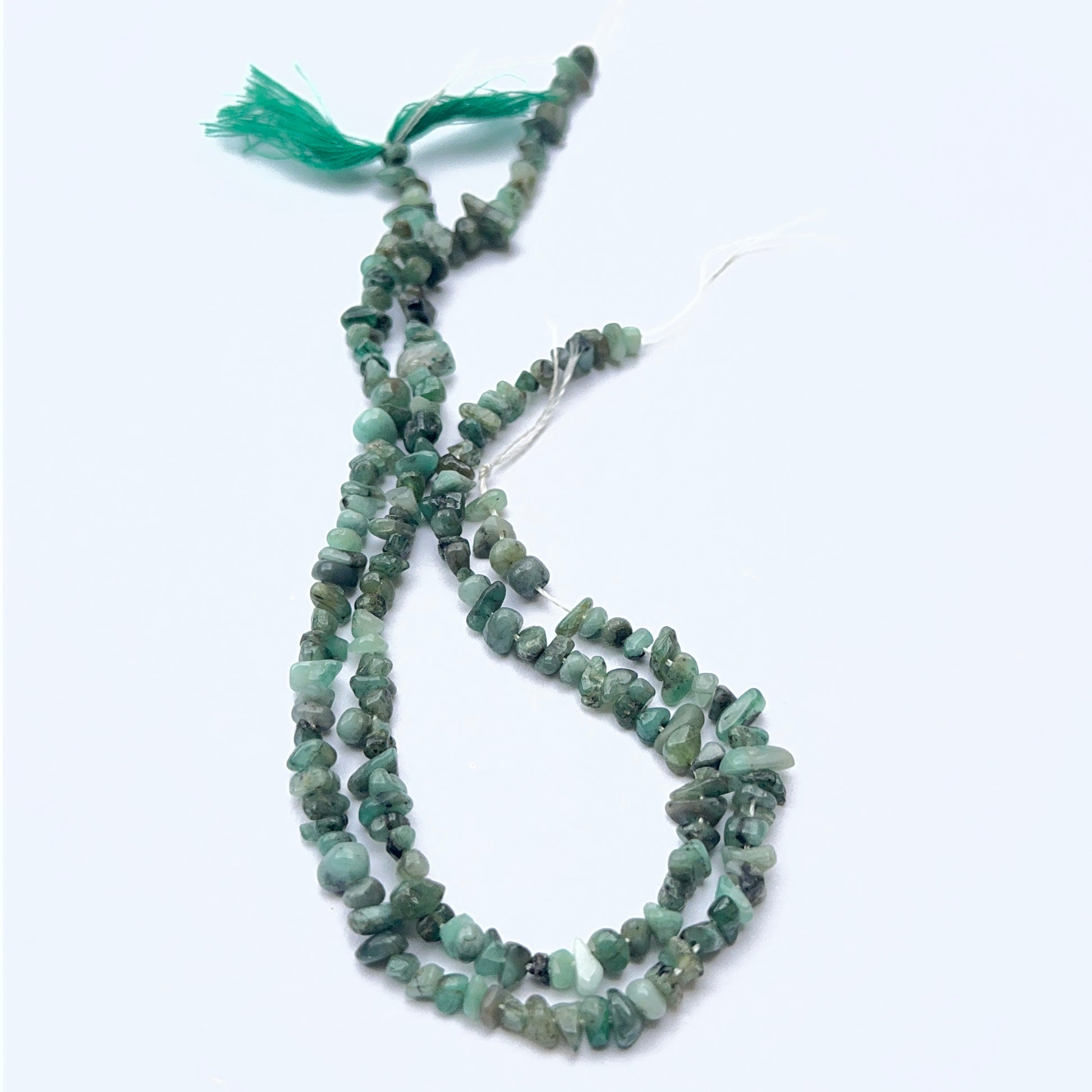 Stone beads in organic emerald chips showcasing raw texture and colour variation.