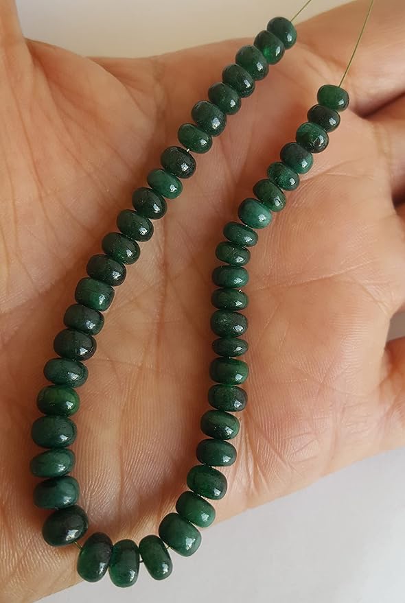 A person holding a strands of smooth rondelle Emerald precious gemstone beads, showcasing their vibrant colour and shine.